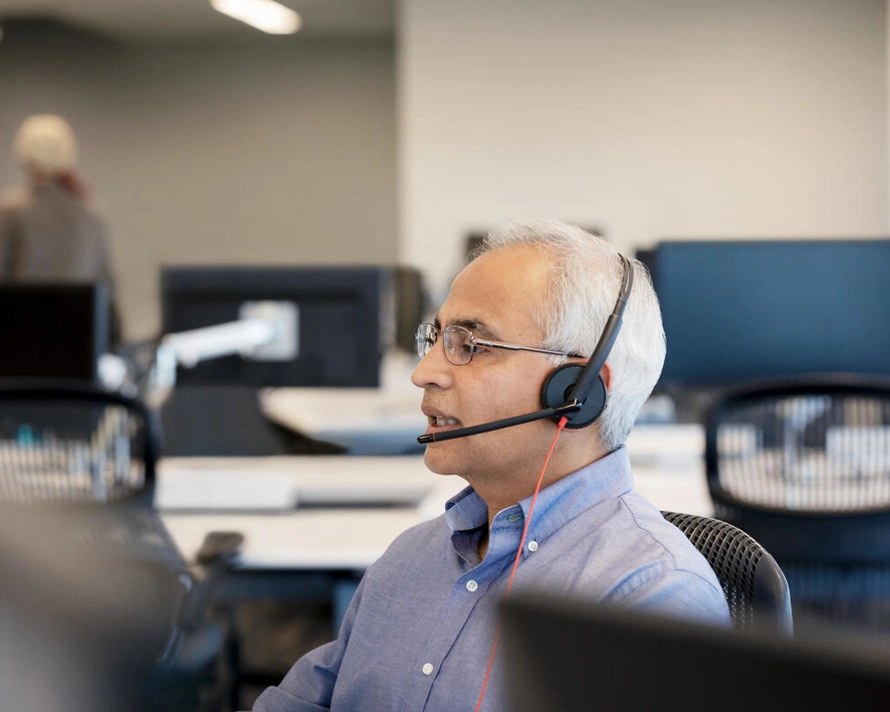 Person talking with headset at office desk
